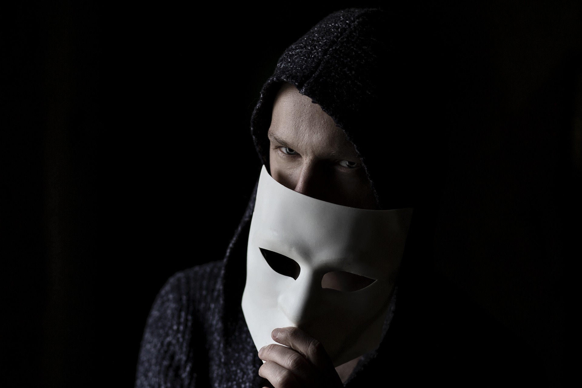 Mann, der sich hinter einer Maske versteckt